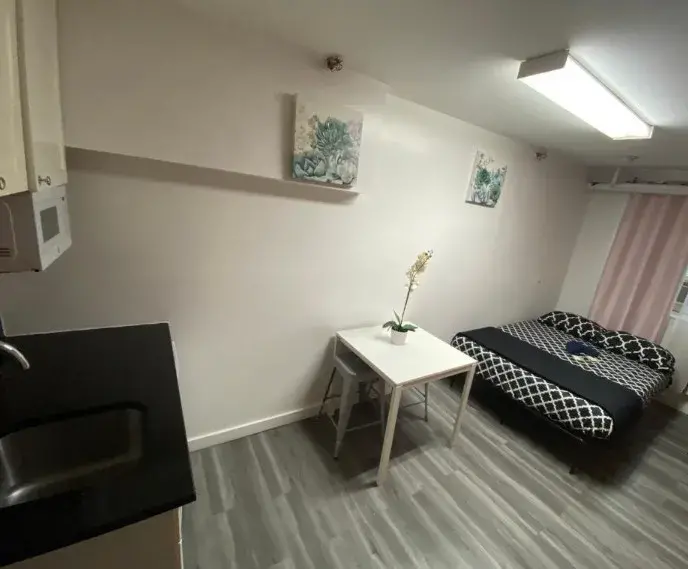 Apartment with a full bed and a table by the window