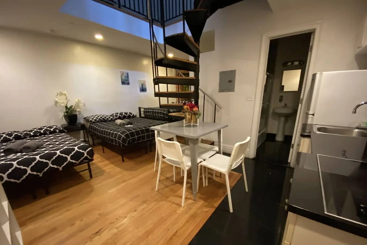 Apartment with beds, a dining table and a spiral staircase