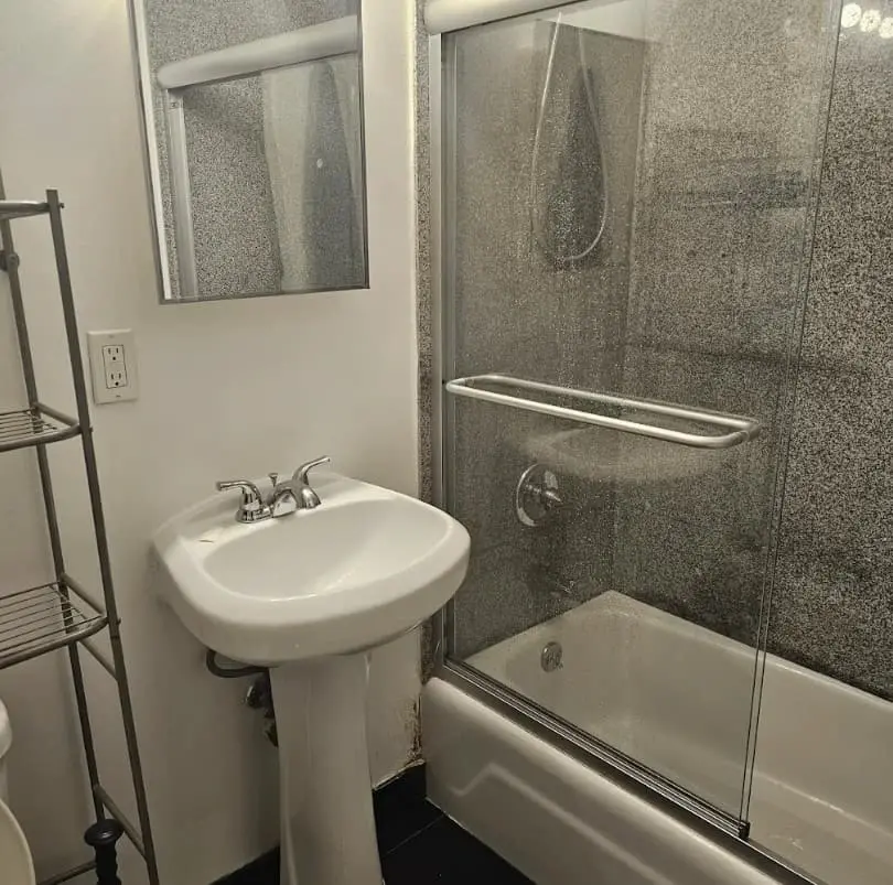 Bathroom with a basin and a bathtub with a glass screen